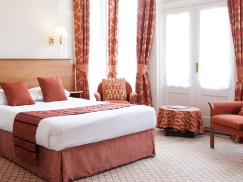 a hotel room with a bed and a chair at TLH Toorak Hotel - TLH Leisure, Entertainment and Spa Resort in Torquay