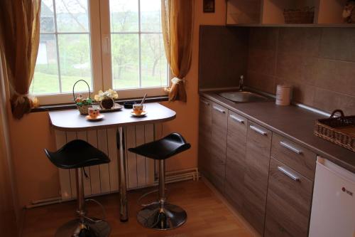 uma cozinha com uma pequena mesa e dois bancos em Rajski vrt em Vrdnik