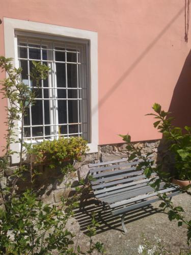 a bench in front of a pink building with a window at BeB Angelini dal 1911 in Lucca