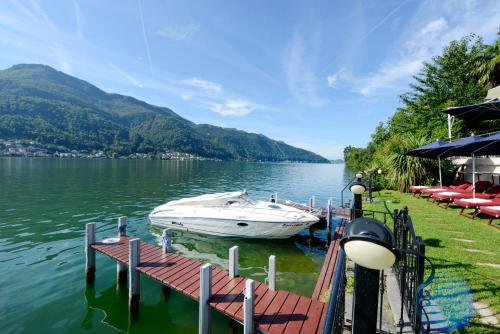 a boat is docked at a dock on a lake at Swiss Diamond Hotel & Spa in Morcote