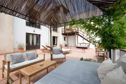 een patio met een bed en stoelen bij Casa Bombo in Granada