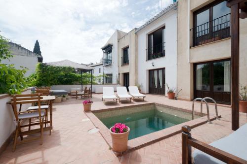 an outdoor patio with a pool and tables and chairs at Casa Bombo in Granada