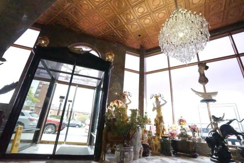 a room with a chandelier and a large window at Paris Suites Hotel in Queens