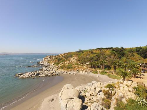 a view of a beach with rocks and the ocean at La Ritoqueña Hotel de Playa in Concón