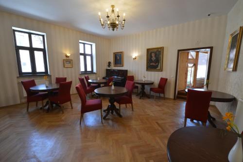 a dining room with tables and chairs and a chandelier at Noblesse Boutique Resort in Sibiu