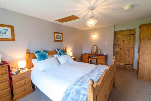 a bedroom with a large bed with blue pillows at Little Abbey Farm in Gayton
