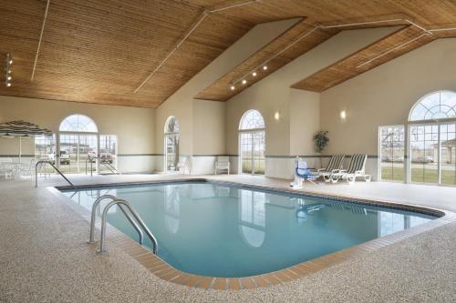 une grande piscine intérieure d'eau bleue dans un bâtiment dans l'établissement Country Inn & Suites by Radisson, Grinnell, IA, à Grinnell