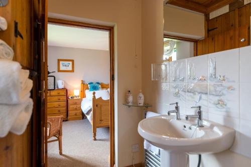 a bathroom with a sink and a bedroom at Little Abbey Farm in Gayton