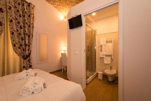 ローマにあるFabiola's Homeのベッドとバスルーム付きのホテルルームです。