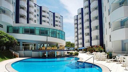 a large building with a swimming pool in front of it at Apartamento no Aguas da Serra TOP in Rio Quente