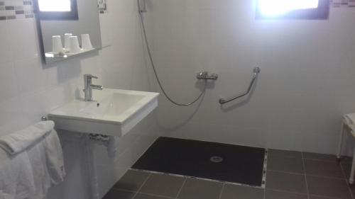 a white bathroom with a sink and a shower at Le Saint Victor in Mirabel-aux-Baronnies