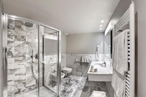 a bathroom with a shower and a toilet and a sink at Hotel Vittoria in Faenza