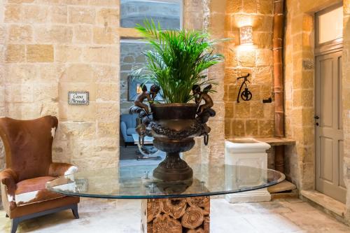einem Glastisch mit einer Vase in der Unterkunft Casa Birmula Boutique Hotel in Cospicua