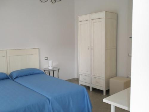 sypialnia z niebieskim łóżkiem i białą szafką w obiekcie Villa Marietta w mieście Civitanova Marche