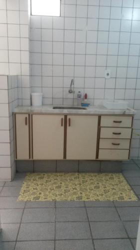 cocina con fregadero y pared de azulejos en Apartamento Atalaia Aracaju, en Aracaju