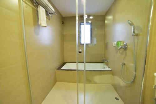 uma casa de banho com um chuveiro e uma banheira em Hotel JIVA em Jamshedpur