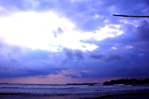 a cloudy sky over a beach with the ocean at Villa Gaetano Unawatuna in Unawatuna