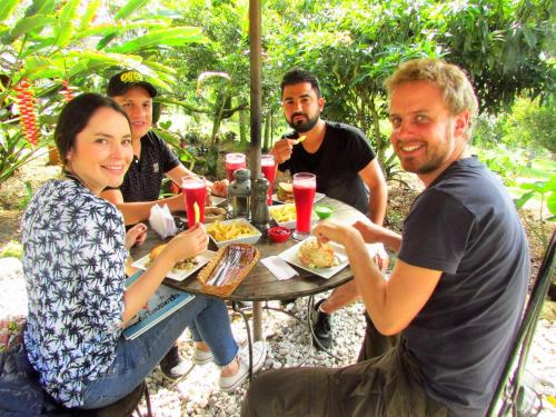 a group of people sitting around a table eating food at Hotel La Casa de Francois in San Agustín