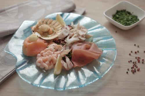 a plate of food with seafood on a table at Hotel Calinferno in Codognè