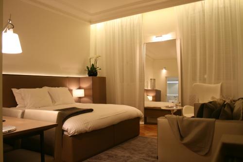 Habitación de hotel con cama y espejo en Cirque Deluxe Studio Apartment, en París
