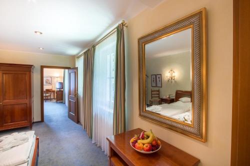 a room with a mirror and a bowl of fruit on a table at Romantik Hotel Stryckhaus in Willingen