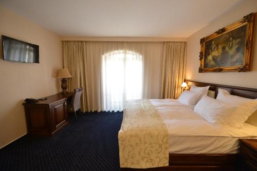 a hotel room with a large bed and a window at Noblesse Boutique Resort in Sibiu