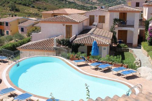 a large swimming pool in front of a house at Residence Bouganvillage in Budoni