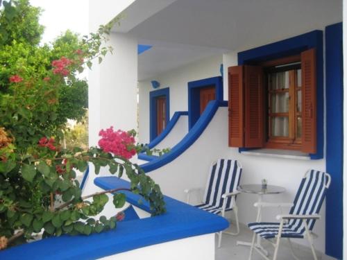 une maison avec des murs bleus et blancs, une table et des chaises dans l'établissement Paradise Studios, à Lipsi