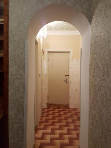 a hallway with a white door and a tile floor at House #1 in Kutaisi