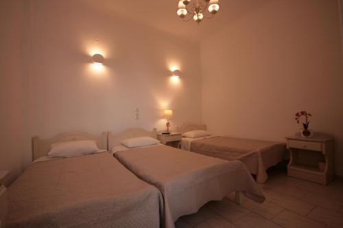 a room with two beds and a chandelier at Pension Anna in Naousa