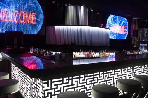 a bar with chairs and neon signs in a room at Hotel Cartoon Razgrad in Razgrad