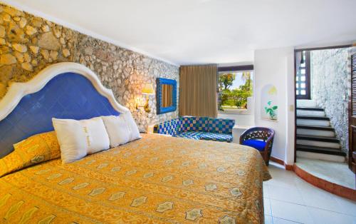 a bedroom with a king sized bed and a staircase at Casa del Mar Cozumel Hotel & Dive Resort with free access to an exclusive beach club in Cozumel