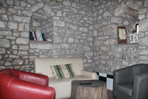a room with a stone wall with a couch and a chair at Agriturismo Castello Di Belforte in Todi