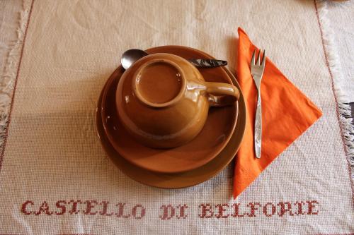 a cup of coffee on a plate on a table at Agriturismo Castello Di Belforte in Todi