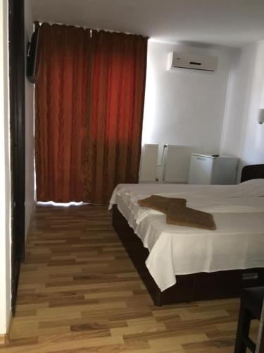 a bedroom with a bed and a red curtain at Vila DG in Mamaia Nord