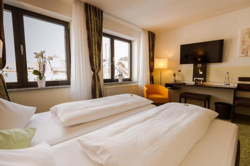 a hotel room with two beds and a window at Hotel Arooma in Erding