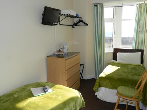 a hotel room with two beds and a television at Ocean Bay in Blackpool