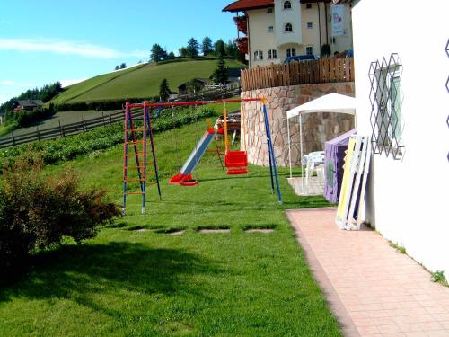 a playground with a slide in the grass at Gasthof Specker in Obereggen