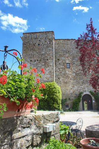 a stone building with flowers in front of it at Agriturismo Castello Di Belforte in Todi