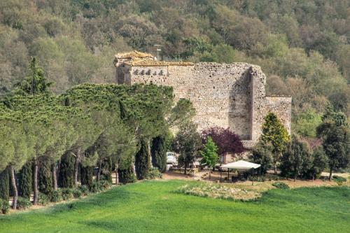 a large stone building with trees in front of it at Agriturismo Castello Di Belforte in Todi