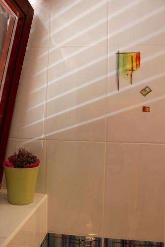 a white tiled wall with a plant on a shelf at Apartments Unija Duga Uvala in Krnica