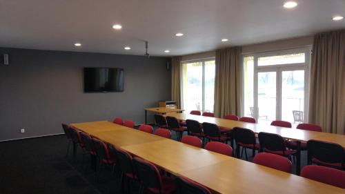 a conference room with a long table and red chairs at OtavArena in Písek