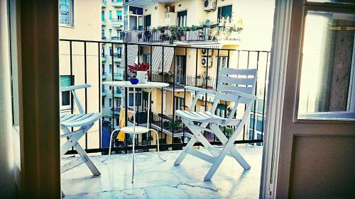 ナポリにあるVerrotti Houseの白い椅子2脚、バルコニー(テーブル付)