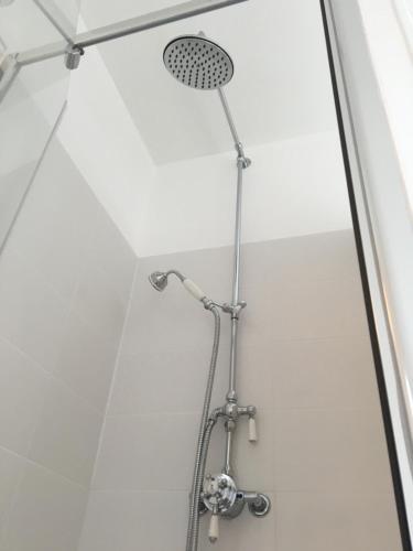 une douche avec pommeau de douche dans une salle de bain dans l'établissement Vue magnifique sur mer, à Saint-Pair-sur-Mer