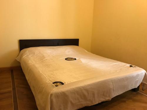 a bed with a white sheet on top of it at Tatev Apartments in Yerevan
