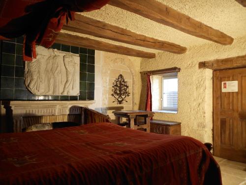sypialnia z łóżkiem, kominkiem i oknem w obiekcie Auberge de l'Abbatiale w mieście Auberive