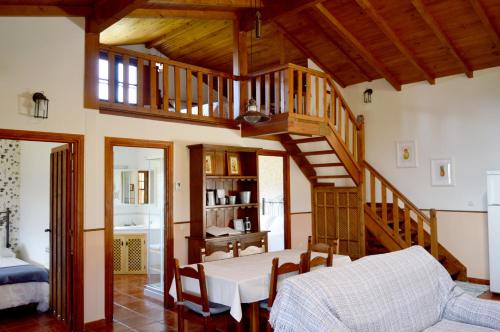 a living room with a wooden staircase and a bedroom at Casa Valeriana in Navaconcejo