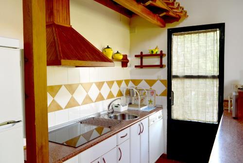 a kitchen with a sink and a stove top oven at Casa Valeriana in Navaconcejo