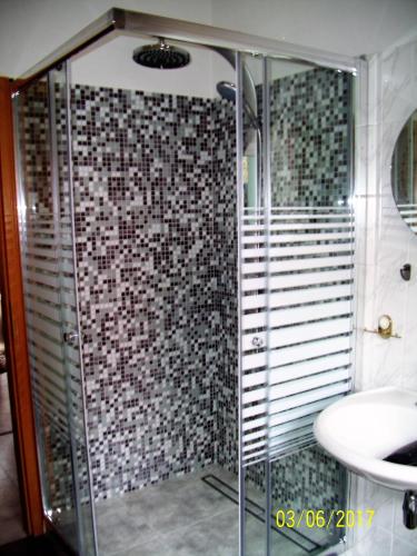 a bathroom with a glass shower and a sink at Ferienwohnung Bauer in Thale