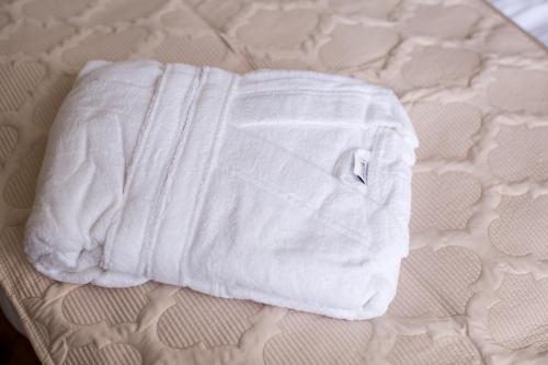 a pile of white towels on a bed at Boutique Hotel Deluxe in Kamianets-Podilskyi